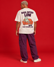 Social Battery Low off-white oversized T-shirt mint tired battery on coral sofa back graphic please recharge alone