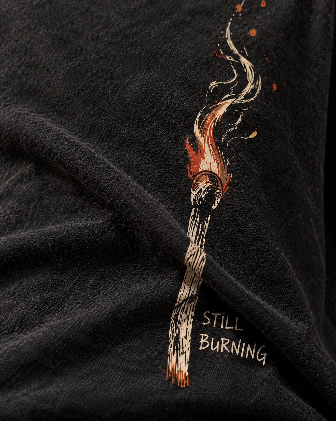 Close-up of Still Burning print bending through cotton fold