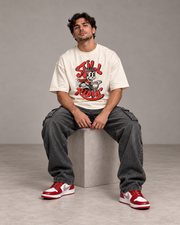 Still Ridin off-white oversized T-shirt seated pose